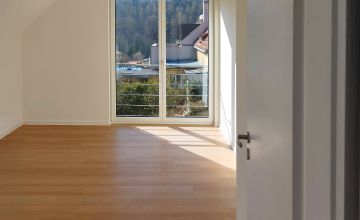 Detail prostorné ložnice s balkonem v druhém patře nového rodinného domu v Praze, zakázková dřevostavba od firmy ALFAHAUS.  